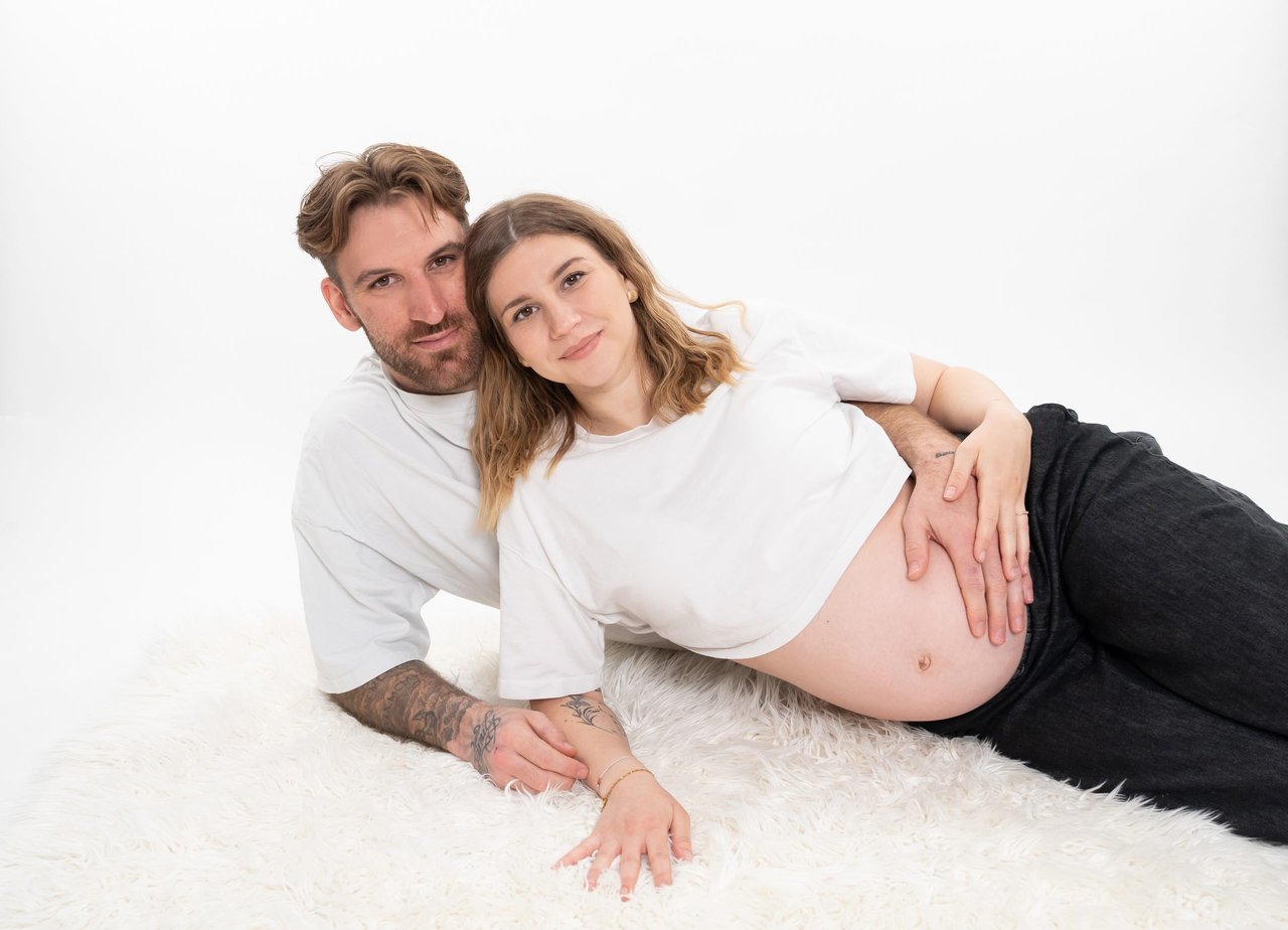 Babybauch-Shooting: Paar liegend mit Bauch, quer 2560px – Photography Ruel, Ebreichsdorf