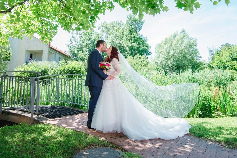 Hochzeitsfotografie: Braut mit wehendem Schleier im Gruenen, quer – Photography Ruel, Ebreichsdorf