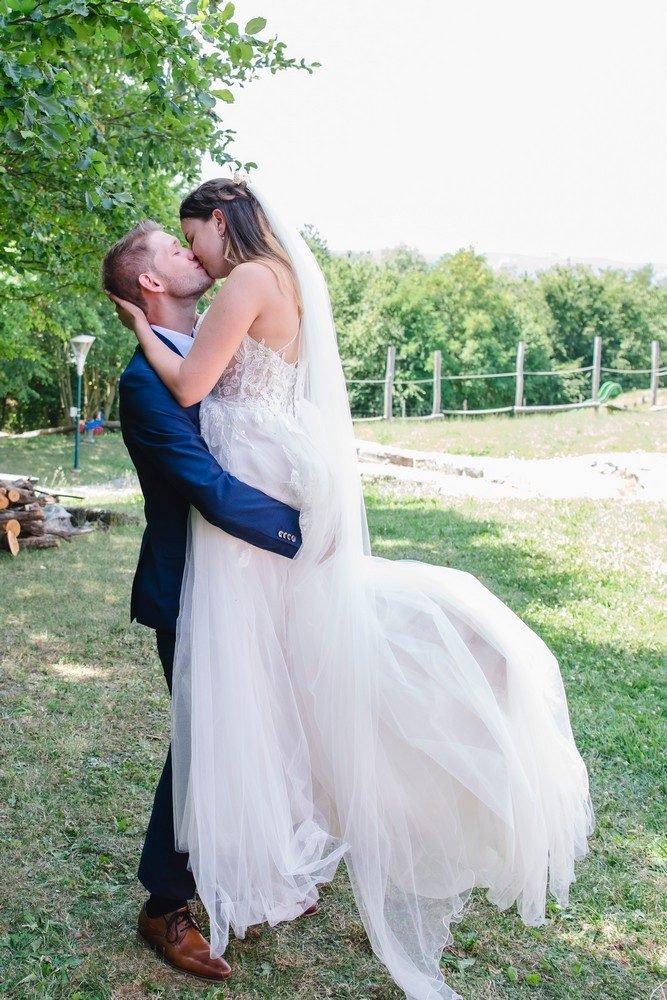 Hochzeitsfotografie: Paar auf Wiese, Kleid fliegt – Photography Ruel, Ebreichsdorf